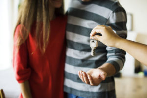 Young couple being given keys to a rental property.